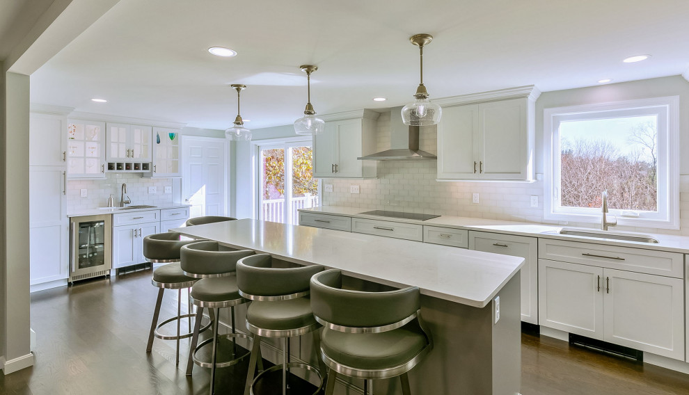 Mid-sized transitional l-shaped dark wood floor kitchen photo in Boston with an undermount sink, shaker cabinets, white cabinets, quartz countertops, white backsplash, subway tile backsplash, stainless steel appliances, an island and white countertops