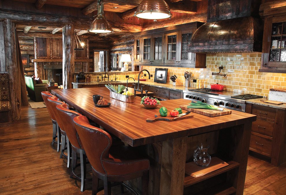 Example of a mountain style eat-in kitchen design in Other with a farmhouse sink, glass-front cabinets, dark wood cabinets, wood countertops, beige backsplash, subway tile backsplash and stainless steel appliances