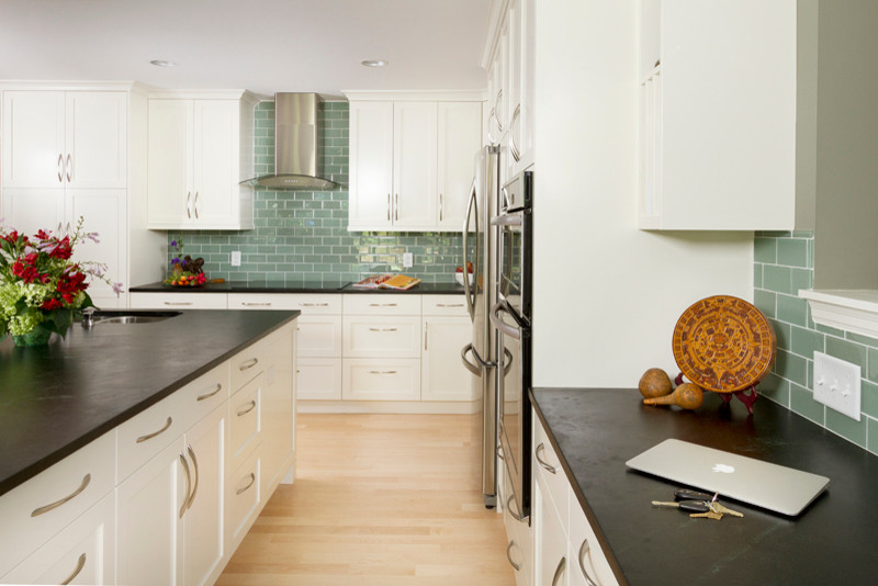 Eat-in kitchen - traditional u-shaped eat-in kitchen idea in Minneapolis with an undermount sink, shaker cabinets, white cabinets, soapstone countertops, green backsplash, glass tile backsplash and stainless steel appliances