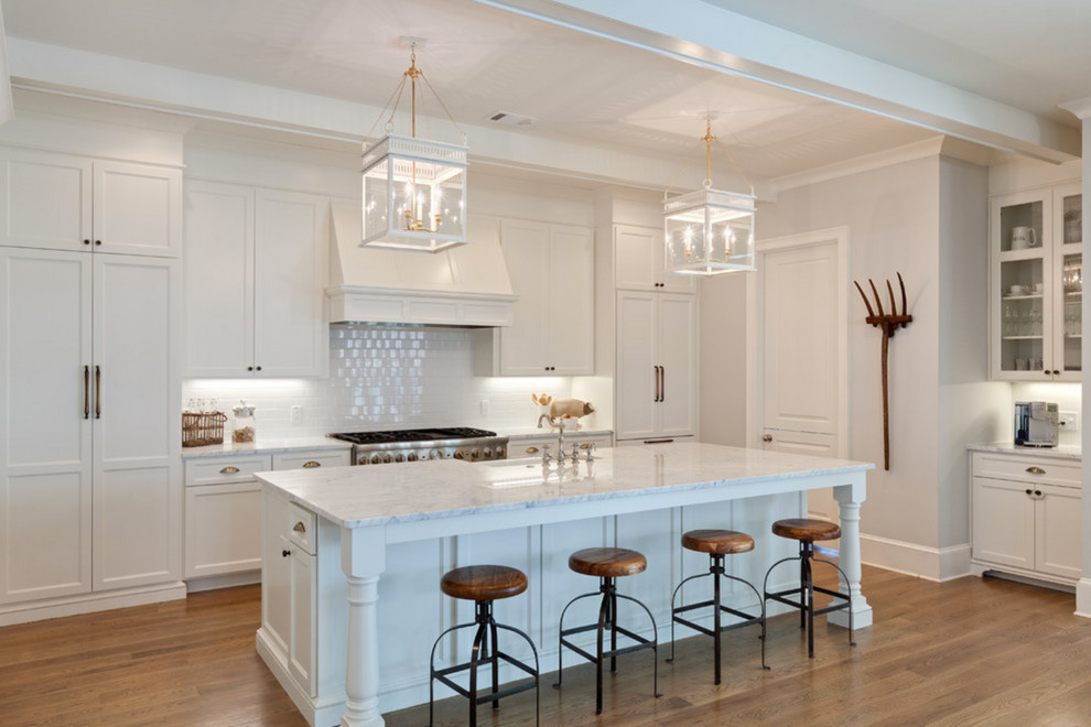 Example of a large country single-wall medium tone wood floor eat-in kitchen design in Los Angeles with shaker cabinets, white cabinets, marble countertops, white backsplash, subway tile backsplash, stainless steel appliances, an island and a farmhouse sink