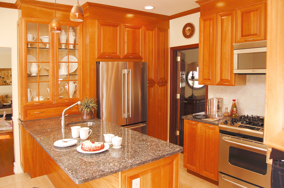 ニューヨークにあるトラディショナルスタイルのおしゃれなキッチン (レイズドパネル扉のキャビネット、シルバーの調理設備、グレーとクリーム色) の写真