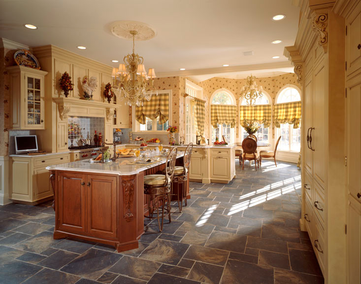 Immagine di una cucina abitabile tradizionale con lavello sottopiano, ante gialle, top in granito e elettrodomestici da incasso