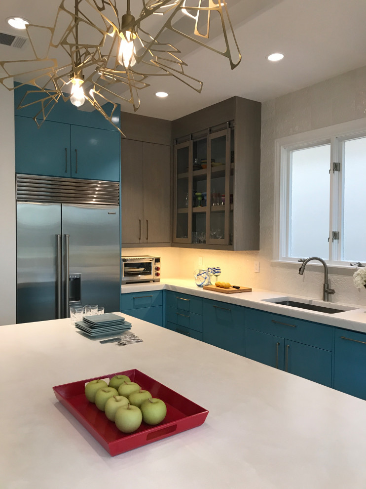 This is an example of a large contemporary l-shaped kitchen in Houston with a submerged sink, flat-panel cabinets, blue cabinets, white splashback, ceramic splashback, stainless steel appliances, light hardwood flooring, an island, beige floors and white worktops.