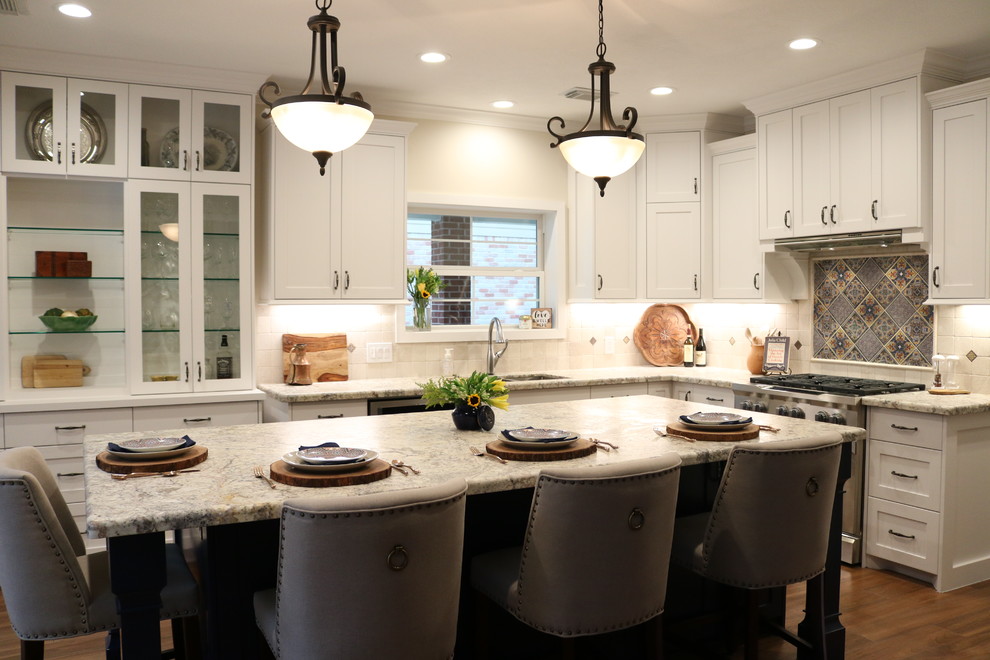 Klassisk inredning av ett grå grått kök, med en nedsänkt diskho, skåp i shakerstil, vita skåp, granitbänkskiva, beige stänkskydd, rostfria vitvaror, klinkergolv i porslin, en köksö och brunt golv