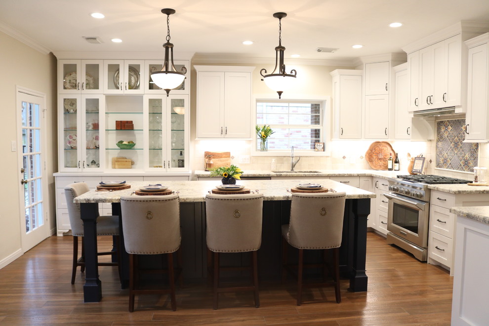 Transitional porcelain tile and brown floor kitchen photo in Houston with a drop-in sink, shaker cabinets, white cabinets, granite countertops, beige backsplash, stainless steel appliances, an island and gray countertops