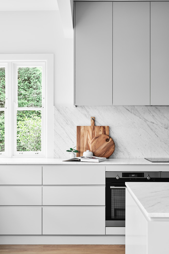 Bild på ett stort funkis flerfärgad flerfärgat kök, med en undermonterad diskho, luckor med profilerade fronter, grå skåp, marmorbänkskiva, grått stänkskydd, stänkskydd i marmor, rostfria vitvaror, ljust trägolv och en köksö