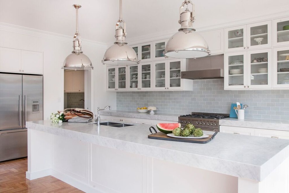Exempel på ett mellanstort klassiskt kök, med en undermonterad diskho, luckor med glaspanel, vita skåp, marmorbänkskiva, grått stänkskydd, stänkskydd i glaskakel, rostfria vitvaror, mellanmörkt trägolv och en köksö
