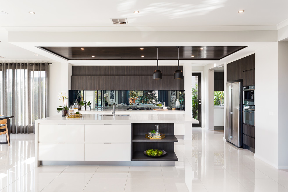 Photo of a medium sized contemporary kitchen/diner in Melbourne with a submerged sink, flat-panel cabinets, an island and white floors.
