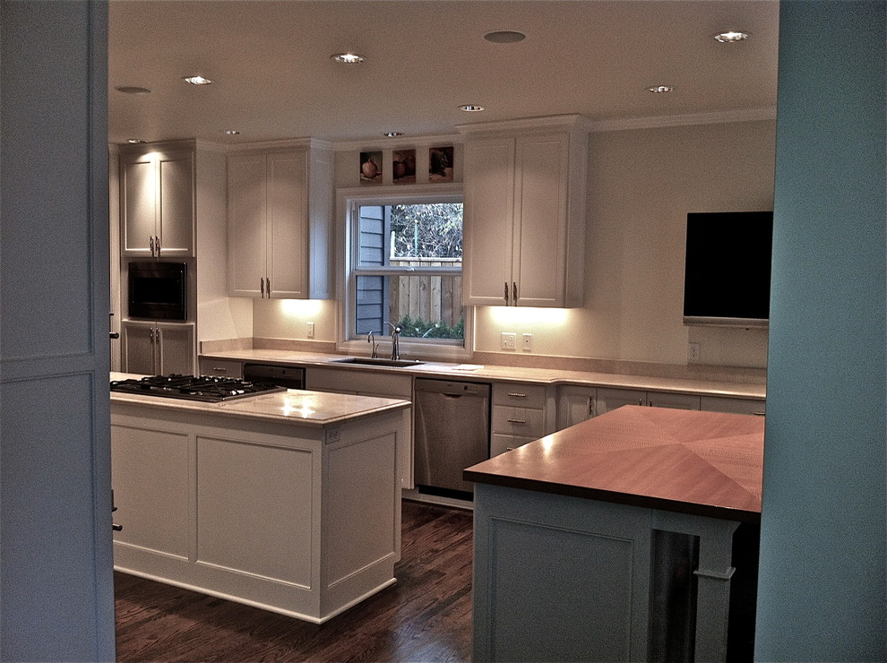 Exempel på ett mycket stort eklektiskt kök och matrum, med en enkel diskho, luckor med profilerade fronter, vita skåp, marmorbänkskiva, beige stänkskydd, stänkskydd i sten, rostfria vitvaror och mörkt trägolv