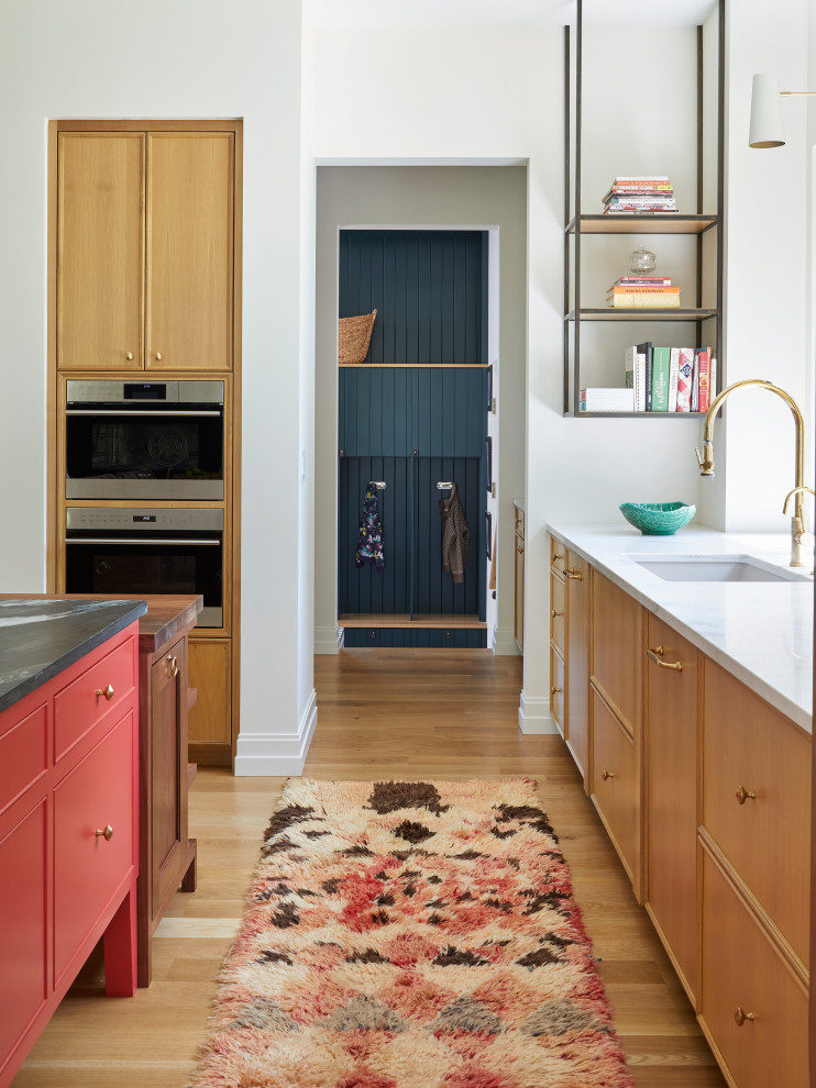 Foto på ett mycket stort lantligt kök, med en undermonterad diskho, luckor med infälld panel, skåp i ljust trä, bänkskiva i kvarts, integrerade vitvaror, ljust trägolv, en köksö och brunt golv