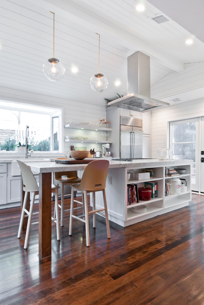 Eat-in kitchen - mid-sized cottage galley painted wood floor eat-in kitchen idea in Los Angeles with a farmhouse sink, shaker cabinets, white cabinets, marble countertops, white backsplash, wood backsplash, stainless steel appliances and an island