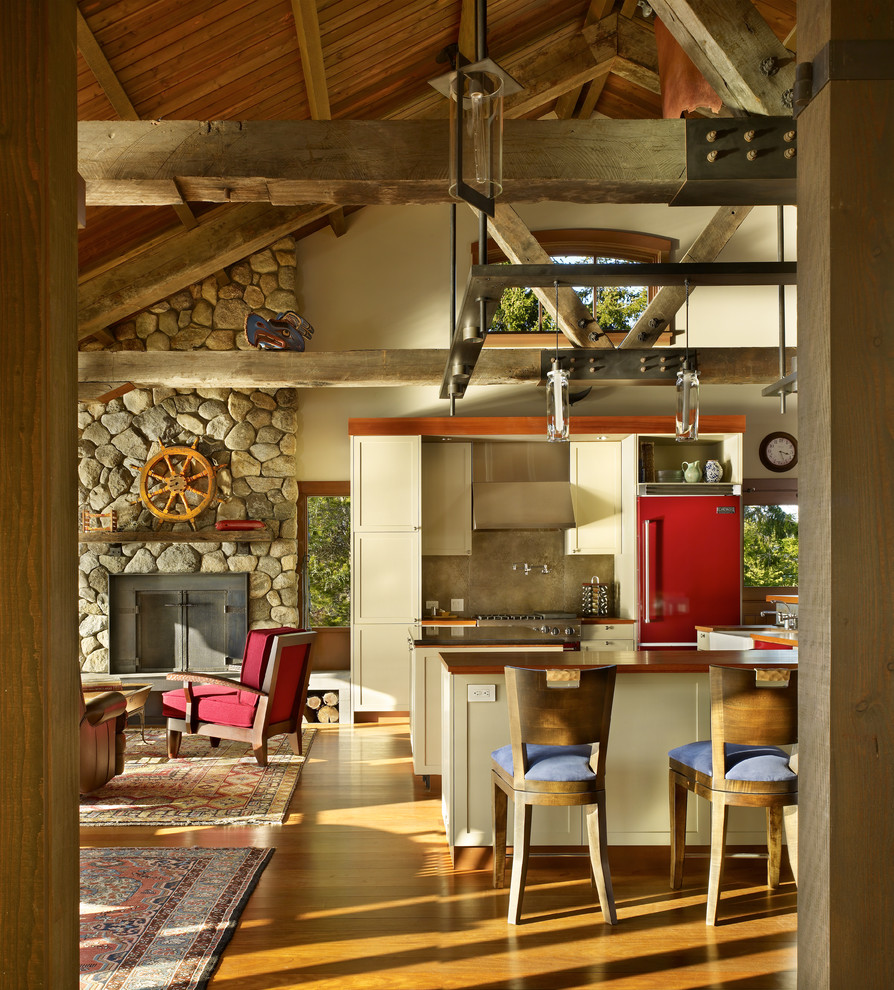 На фото: кухня-гостиная в стиле рустика с фасадами в стиле шейкер, бежевыми фасадами, деревянной столешницей и цветной техникой