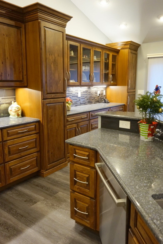 Rustik inredning av ett stort kök och matrum, med en undermonterad diskho, luckor med upphöjd panel, skåp i mellenmörkt trä, bänkskiva i kvarts, grått stänkskydd, stänkskydd i metallkakel, en köksö och grått golv