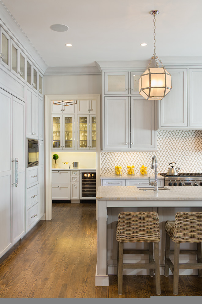 Inspiration for a traditional l-shaped kitchen in DC Metro with recessed-panel cabinets, white cabinets, white splashback, integrated appliances and medium hardwood flooring.