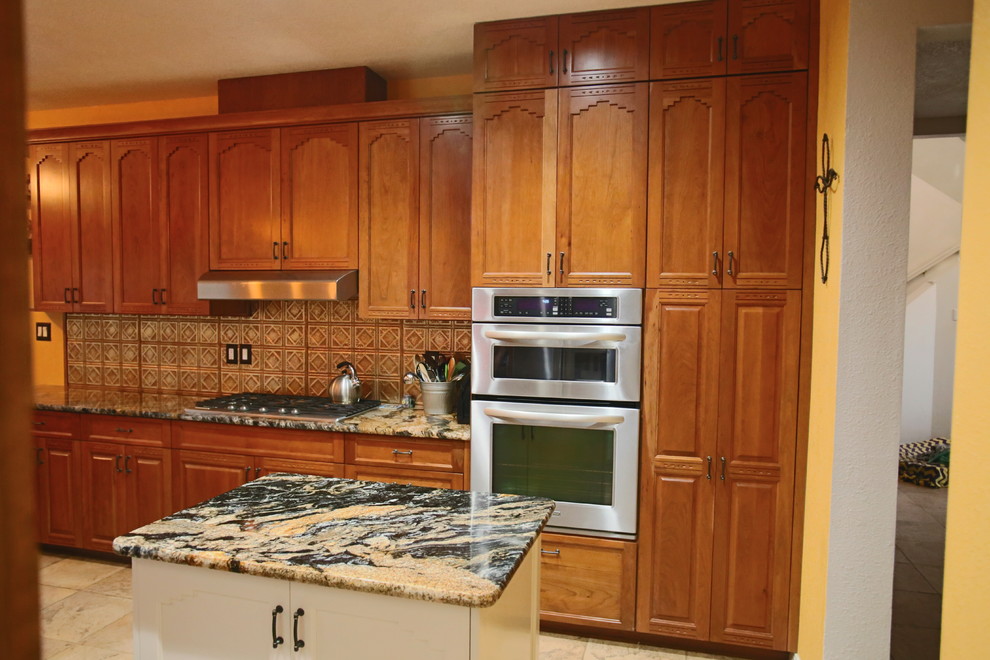 Exempel på ett mellanstort amerikanskt kök, med travertin golv, luckor med upphöjd panel, skåp i mellenmörkt trä, stänkskydd i glaskakel, rostfria vitvaror, en köksö, beiget golv, granitbänkskiva och brunt stänkskydd