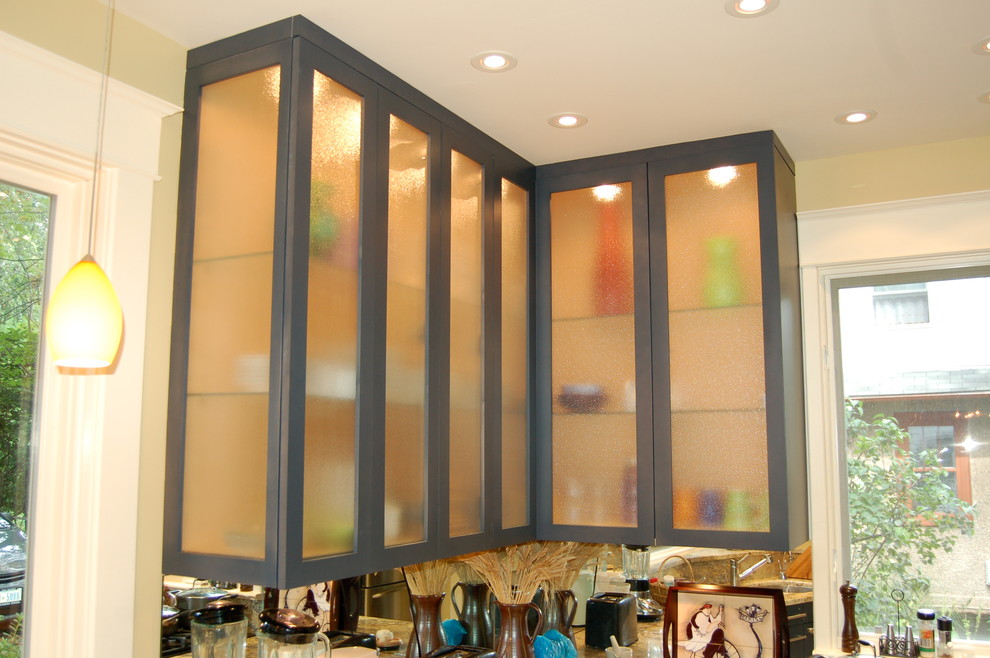 ワシントンD.C.にある中くらいなモダンスタイルのおしゃれな独立型キッチン (ガラス扉のキャビネット、大理石カウンター、黄色いキッチンパネル、セラミックタイルの床) の写真