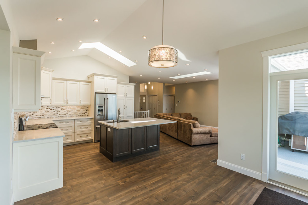 Mid-sized arts and crafts l-shaped laminate floor and brown floor eat-in kitchen photo in Vancouver with an undermount sink, shaker cabinets, white cabinets, quartzite countertops, multicolored backsplash, mosaic tile backsplash, stainless steel appliances, an island and white countertops
