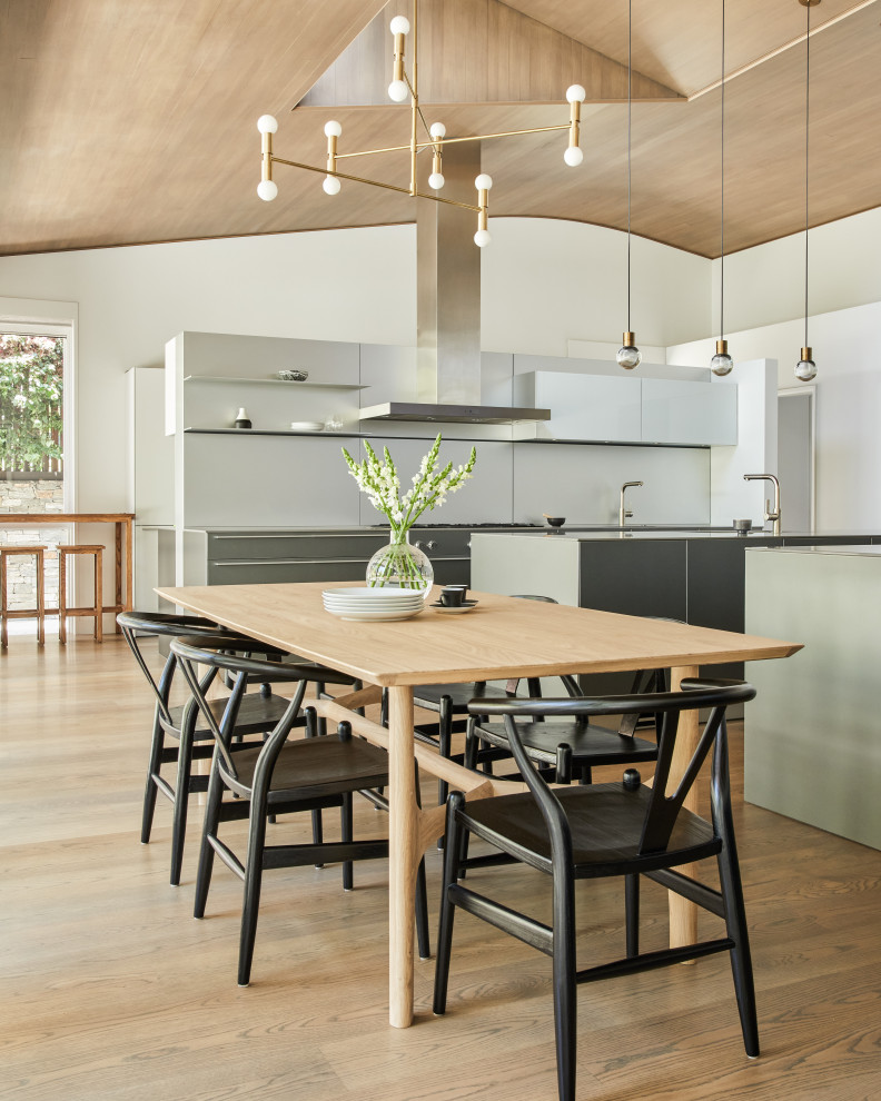 Example of a huge trendy galley medium tone wood floor, brown floor and wood ceiling open concept kitchen design in Los Angeles with flat-panel cabinets, gray cabinets, stainless steel appliances and two islands