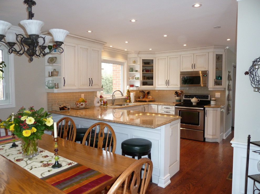 Example of a mid-sized classic u-shaped medium tone wood floor and brown floor eat-in kitchen design in Toronto with a double-bowl sink, raised-panel cabinets, white cabinets, beige backsplash, stainless steel appliances and no island