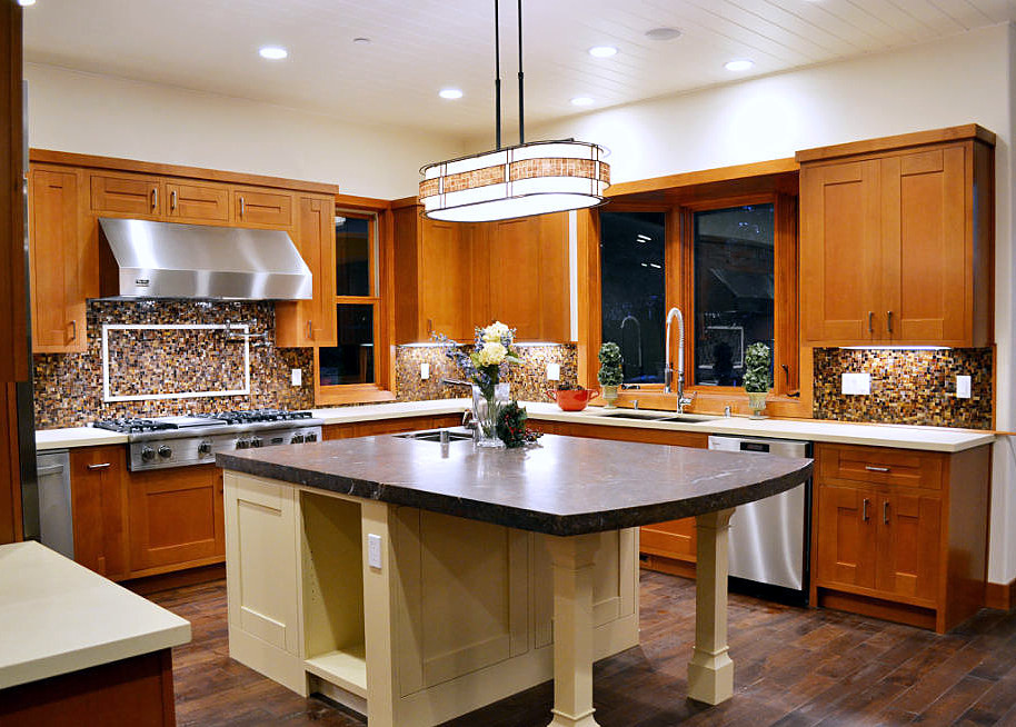 Inredning av ett rustikt kök, med en dubbel diskho, skåp i shakerstil, bruna skåp, bänkskiva i kvartsit, flerfärgad stänkskydd, rostfria vitvaror, mörkt trägolv och en köksö
