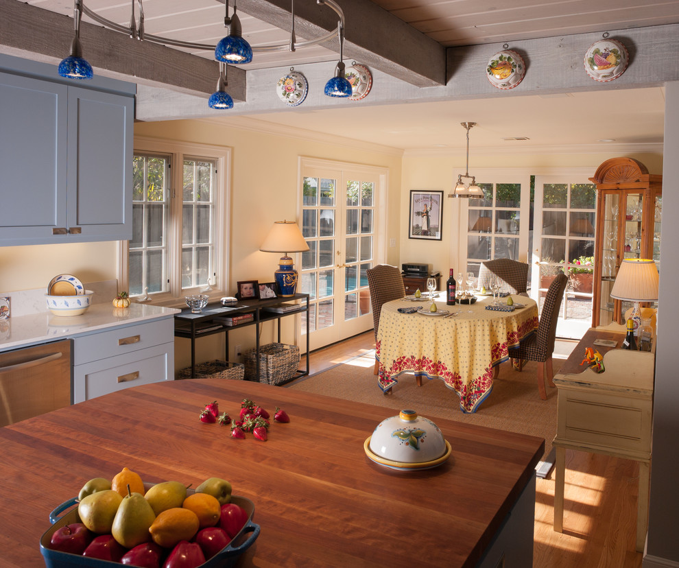 Bild på ett mellanstort lantligt kök, med en rustik diskho, skåp i shakerstil, blå skåp, bänkskiva i kvarts, stänkskydd i mosaik, rostfria vitvaror, mellanmörkt trägolv och en köksö