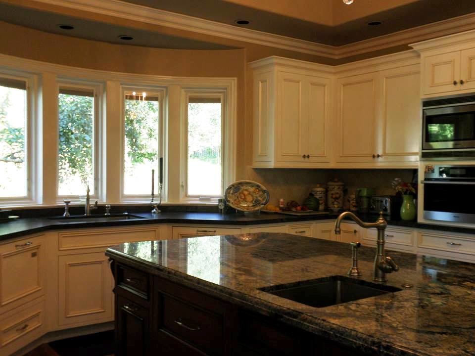Inspiration for a traditional l-shaped enclosed kitchen in San Francisco with a built-in sink, flat-panel cabinets, white cabinets, granite worktops, beige splashback, ceramic splashback, stainless steel appliances, dark hardwood flooring and an island.