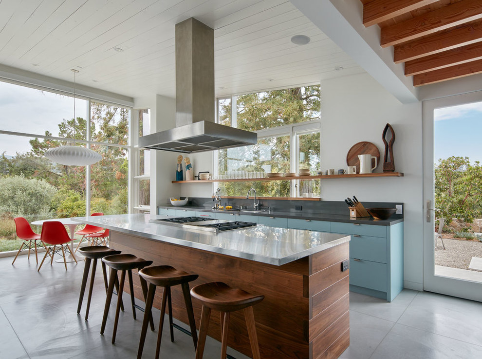Esempio di una cucina minimalista con lavello sottopiano, ante lisce, ante blu, top in acciaio inossidabile, paraspruzzi grigio, elettrodomestici da incasso, pavimento in cemento, pavimento grigio e top grigio