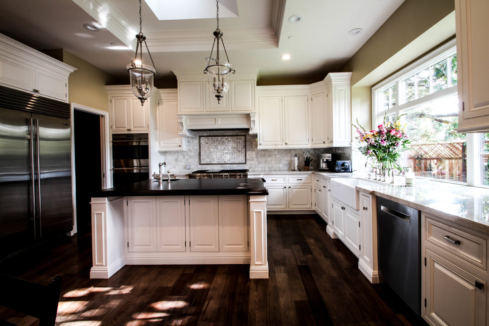Large elegant u-shaped medium tone wood floor kitchen photo in San Francisco with a farmhouse sink, beaded inset cabinets, white cabinets, laminate countertops, stainless steel appliances and two islands
