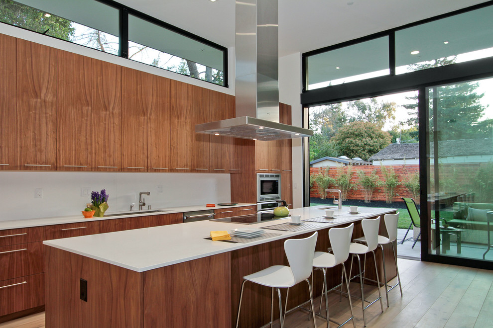 Modern kitchen in San Francisco with flat-panel cabinets, medium wood cabinets, white splashback and stainless steel appliances.
