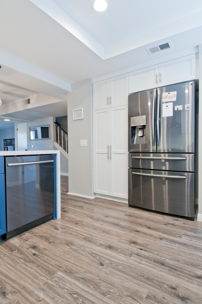 Idee per una piccola cucina moderna chiusa con ante lisce, ante blu, top in marmo, elettrodomestici in acciaio inossidabile, pavimento in legno massello medio e pavimento grigio