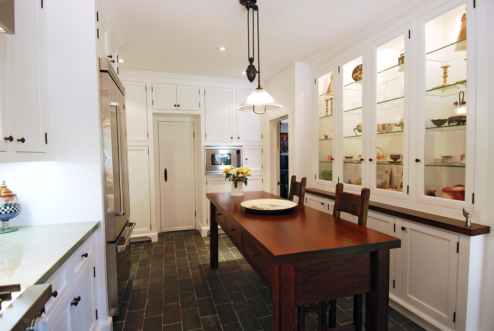 Exempel på ett lantligt kök, med luckor med glaspanel, rostfria vitvaror och skiffergolv
