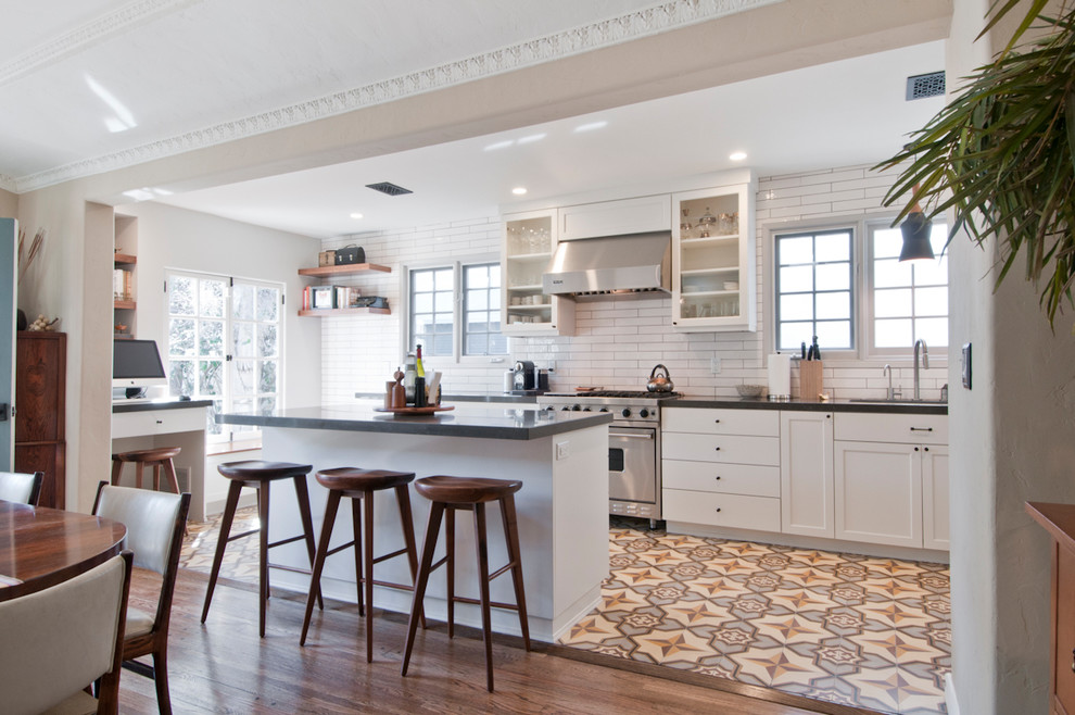 Bild på ett mellanstort vintage kök, med en undermonterad diskho, skåp i shakerstil, vita skåp, bänkskiva i kvartsit, vitt stänkskydd, stänkskydd i keramik, rostfria vitvaror, cementgolv, en köksö och flerfärgat golv