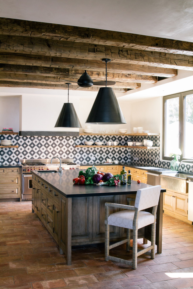 Идея дизайна: угловая кухня-гостиная в средиземноморском стиле с с полувстраиваемой мойкой (с передним бортиком), открытыми фасадами, светлыми деревянными фасадами, разноцветным фартуком, техникой из нержавеющей стали, полом из терракотовой плитки, островом, розовым полом и красивой плиткой