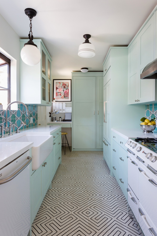 Example of a small eclectic galley multicolored floor and cement tile floor kitchen design in Los Angeles with shaker cabinets, no island, a farmhouse sink, green cabinets, multicolored backsplash, white appliances and white countertops