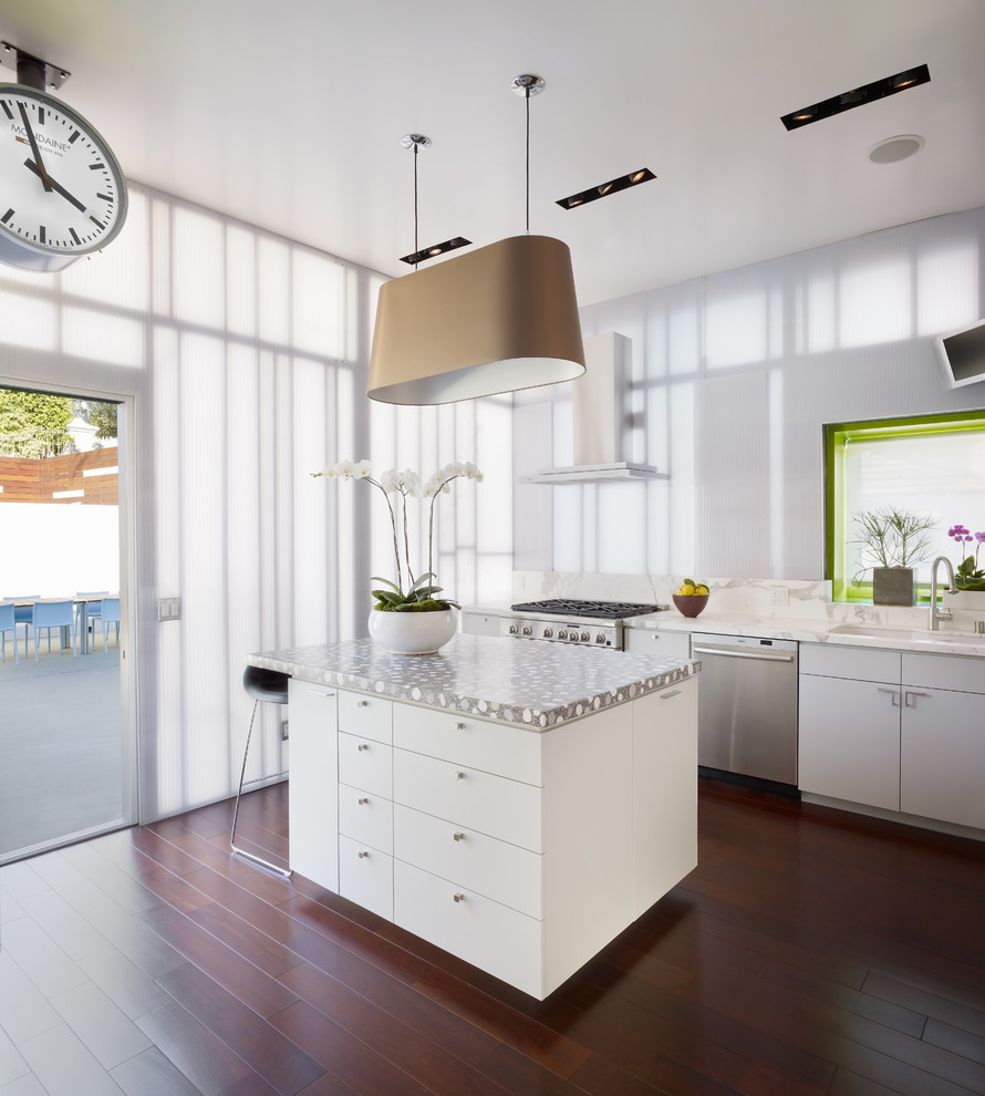Cette photo montre une cuisine tendance avec un placard à porte plane et des portes de placard blanches.