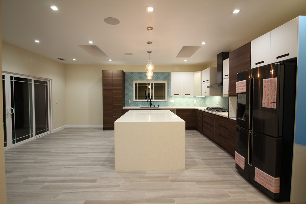 Example of a large minimalist l-shaped porcelain tile and gray floor enclosed kitchen design in Sacramento with an undermount sink, flat-panel cabinets, dark wood cabinets, quartz countertops, green backsplash, glass tile backsplash, stainless steel appliances, an island and white countertops
