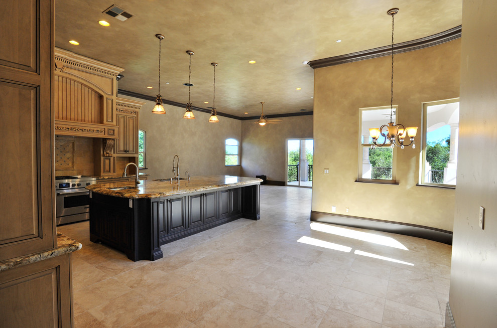 Eat-in kitchen - large mediterranean l-shaped travertine floor and beige floor eat-in kitchen idea in Sacramento with a double-bowl sink, raised-panel cabinets, beige cabinets, marble countertops, beige backsplash, stone tile backsplash, stainless steel appliances and an island