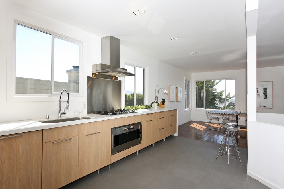 Immagine di una cucina abitabile contemporanea con ante lisce e ante in legno chiaro