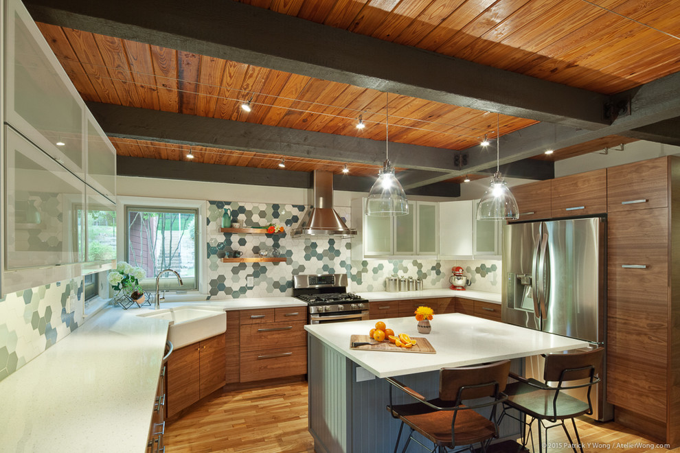 Example of a small mid-century modern u-shaped medium tone wood floor eat-in kitchen design in Austin with a farmhouse sink, flat-panel cabinets, medium tone wood cabinets, quartz countertops, multicolored backsplash, mosaic tile backsplash, stainless steel appliances and an island