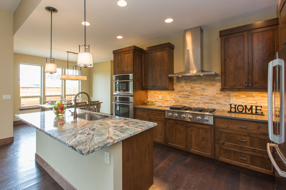 Example of a large classic galley dark wood floor eat-in kitchen design in Portland with a single-bowl sink, shaker cabinets, dark wood cabinets, quartzite countertops, beige backsplash, stainless steel appliances and an island