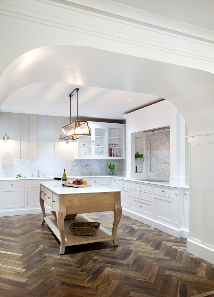 Inspiration för ett stort vintage kök, med en undermonterad diskho, luckor med profilerade fronter, vita skåp, marmorbänkskiva, vitt stänkskydd, stänkskydd i sten, rostfria vitvaror, mörkt trägolv och en köksö