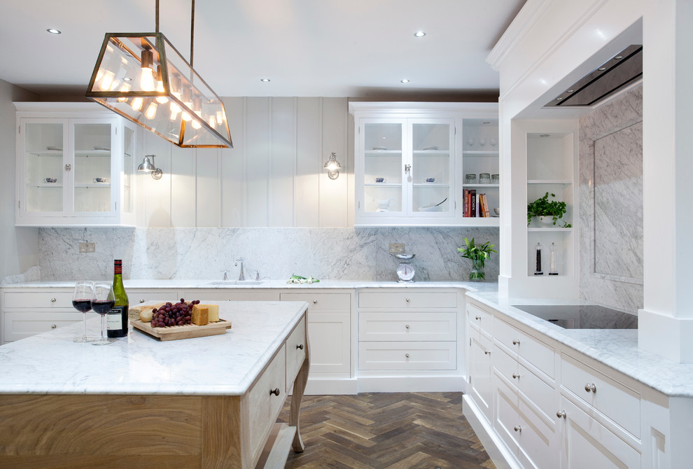 This is an example of a large eclectic u-shaped kitchen pantry in Dublin with a submerged sink, beaded cabinets, white cabinets, marble worktops, white splashback, stone slab splashback, stainless steel appliances, dark hardwood flooring and an island.