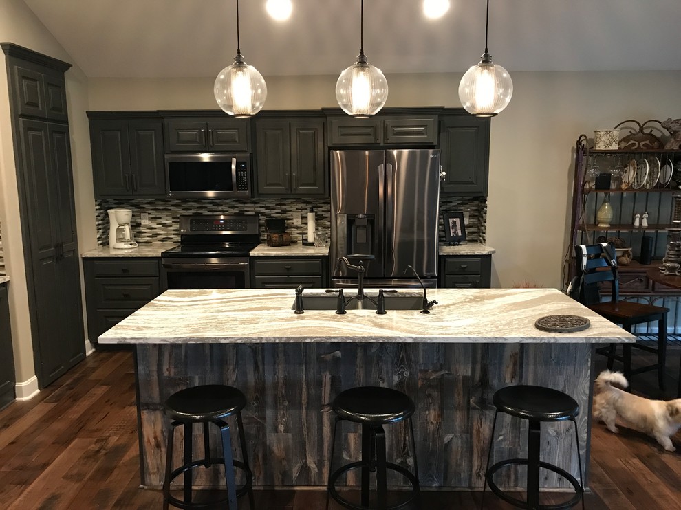 Exempel på ett litet klassiskt linjärt kök, med en dubbel diskho, luckor med upphöjd panel, grå skåp, bänkskiva i kvartsit, flerfärgad stänkskydd, stänkskydd i glaskakel, rostfria vitvaror, mellanmörkt trägolv, en köksö och brunt golv