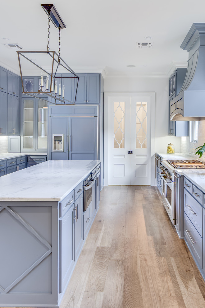 Foto di un cucina con isola centrale classico con ante in stile shaker, ante viola, elettrodomestici da incasso, parquet chiaro, pavimento beige e top bianco
