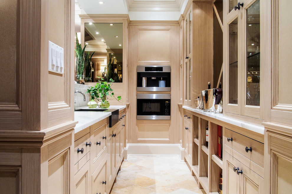 Design ideas for a traditional galley kitchen in New York with a belfast sink, recessed-panel cabinets, light wood cabinets, marble worktops and integrated appliances.