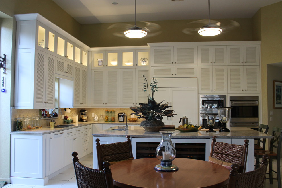 Источник вдохновения для домашнего уюта: кухня в классическом стиле с фасадами с филенкой типа жалюзи, белыми фасадами и обеденным столом