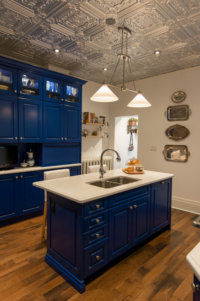 トロントにあるカントリー風のおしゃれな独立型キッチン (ダブルシンク、レイズドパネル扉のキャビネット、青いキャビネット) の写真