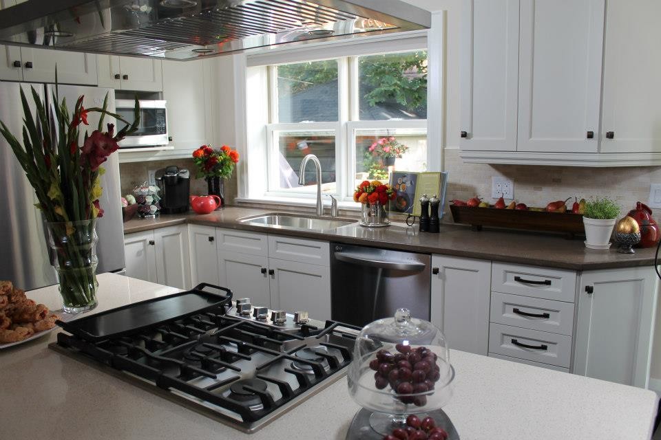 Exempel på ett litet klassiskt kök, med en undermonterad diskho, skåp i shakerstil, vita skåp, bänkskiva i kvarts, grått stänkskydd, stänkskydd i keramik, rostfria vitvaror, mörkt trägolv och en köksö