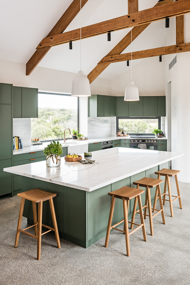 Design ideas for a large contemporary l-shaped open plan kitchen in Melbourne with a belfast sink, green cabinets, marble worktops, white splashback, marble splashback, black appliances, concrete flooring, an island, grey floors, white worktops and flat-panel cabinets.