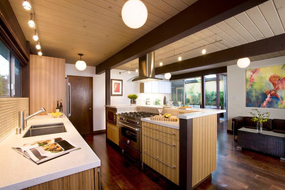 Foto på ett mellanstort funkis vit kök, med släta luckor, beige stänkskydd, rostfria vitvaror, en undermonterad diskho, skåp i ljust trä, bänkskiva i kvarts, stänkskydd i keramik, mörkt trägolv, en köksö och brunt golv